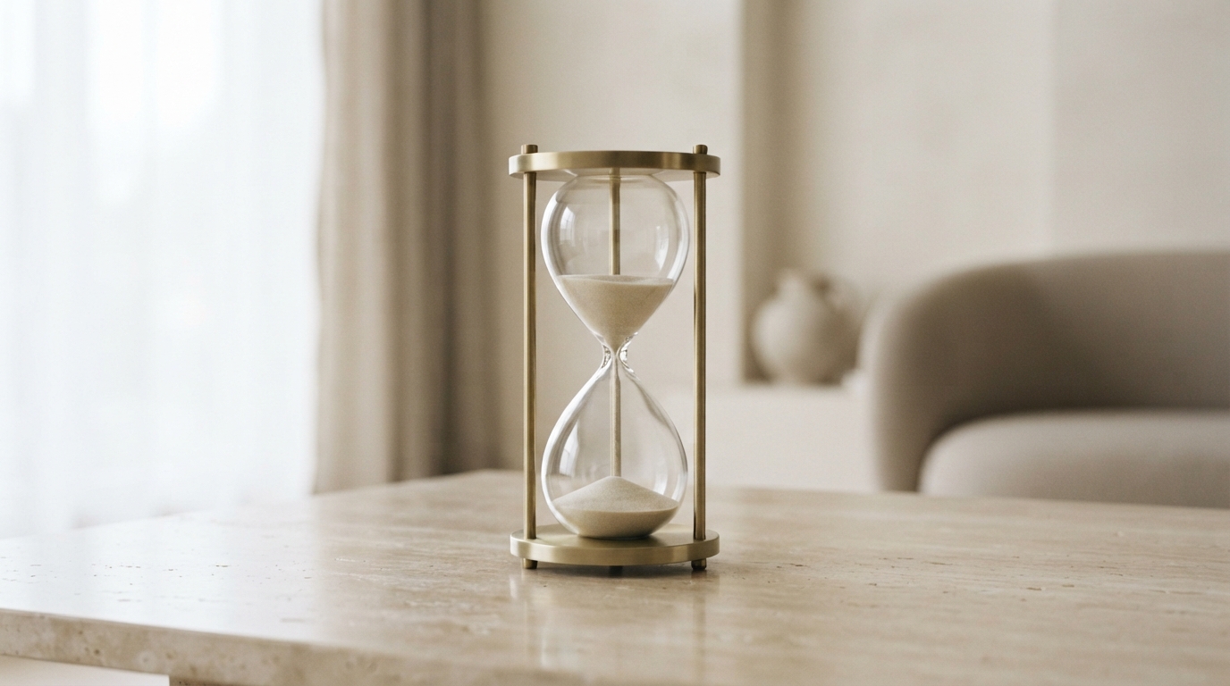 Brass hourglass with falling sand on a travertine table