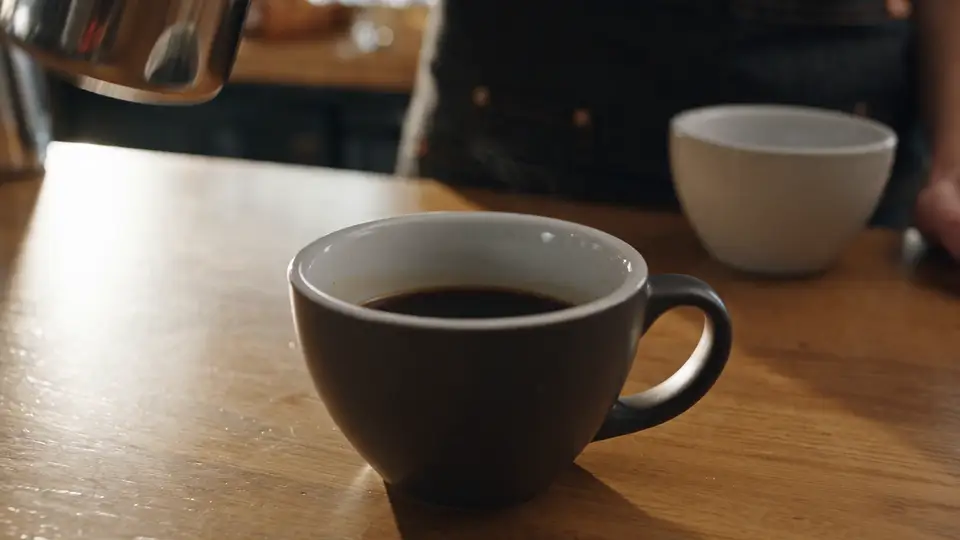 The 5-second Seedance 2.5 clip from our run: a barista pours steamed milk into an espresso and latte art forms